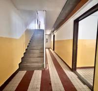 Eingangsflur mit Fliesen in einer 3-Zimmer-Wohnung, Treppenhaus und bunte Wände.