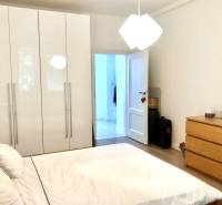 Schlafzimmer in einer 2-Zimmer-Wohnung mit weißem Schrank, Bett und Kommode.
