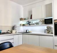 Küche in einer 2-Zimmer-Wohnung mit weißen Schränken und eingebauten Geräten.