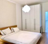 Schlafzimmer in einer 2-Zimmer-Wohnung mit weißem Schrank und Boden in Holzoptik.