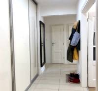 Der Flur mit Fliesen und einem Schrank in einer 2-Zimmer-Wohnung, mit Kleiderhaken.