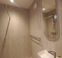 Badezimmer mit Dusche und Waschbecken in einer 4-Zimmer-Wohnung.