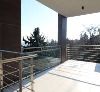 Ein Balkon mit Geländer und Blick auf die Stadt von einer 4-Zimmer-Wohnung in Bratislava.