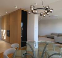 Wohnzimmer mit Esstisch, Sofa und Leuchte in einer 4-Zimmer-Wohnung, Boden mit Holzdekor.