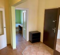 Flur mit dunklen Türen, Boden mit Holzdekor, Blick ins Zimmer.