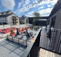 Der Außenbereich des Platzes bei der Sýpka in Bratislava - Jarovce mit Terrasse und Backsteingebäuden.