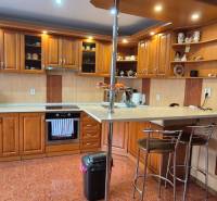 Küche in einem Einfamilienhaus mit Holzdekor, ausgestattet mit Geräten und einer Bar.