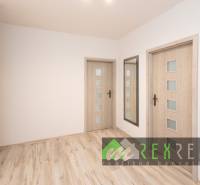 Flur in einer 3-Zimmer-Wohnung mit Holzboden und Spiegel.