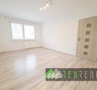 Ein Zimmer in einer 3-Zimmer-Wohnung mit einem Boden in Holzoptik und einem Fenster.