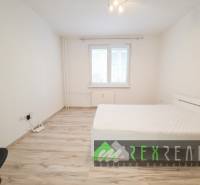 Helles Schlafzimmer in einer 3-Zimmer-Wohnung mit Holzboden und einfacher Einrichtung.