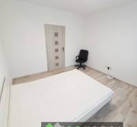 Helles Schlafzimmer in einer 3-Zimmer-Wohnung mit Holzboden und Bürostuhl.