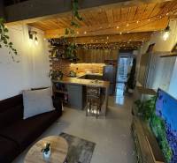 Wohnzimmer mit Ziegelverkleidung, Küchenzeile und Holzboden. Lager und Hallen.