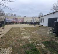 Der Hof des Einfamilienhauses in Hernádkak mit Pflastersteinen und einer Außensitzgelegenheit auf dem Grundstück.