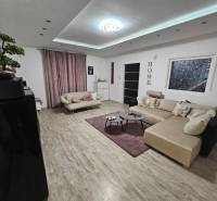 Wohnzimmer in einem Einfamilienhaus mit Holzboden und großem Sofa.