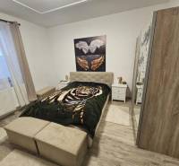 Schlafzimmer mit Bett, Schrank und Holzboden in einem Einfamilienhaus.