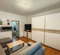 Wohnzimmer in einem Einfamilienhaus mit Holzboden, Sofa und Bildern an der Wand.