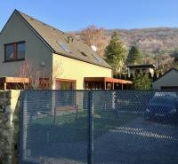 Ein Einfamilienhaus in der Kremeľská-Straße in Bratislava - Devín, umgeben von einem Garten und Bergen.