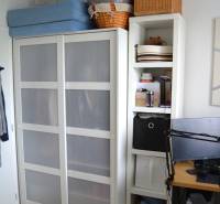 Innenraum einer 3-Zimmer-Wohnung mit weißem Schrank und Regalen, Boden mit Holzdekor.