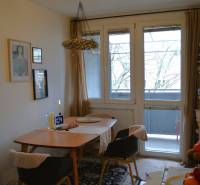 Essbereich in einer 3-Zimmer-Wohnung mit Teppichdekor und verglasten Balkontüren.