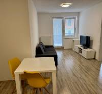 Wohnzimmer einer 2-Zimmer-Wohnung mit Holzboden und heller Sitzecke.