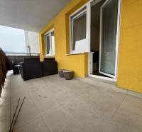 Balkon einer 2-Zimmer-Wohnung in Žilina mit gefliestem Boden und Gartenmöbeln.