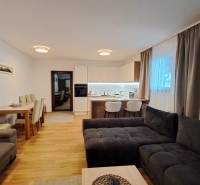 Wohnzimmer einer 2-Zimmer-Wohnung mit Küche, Esstisch und Holzboden.