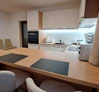 Küche in einer 2-Zimmer-Wohnung mit eingebauten Geräten und einem Boden in Holzoptik.