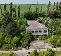 Ein Gebäude umgeben von Vegetation, geeignet für Gewerbegrundstücke in Ivanka pri Nitre.