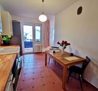 Küche in einer 4-Zimmer-Wohnung mit Fliesenboden, Esstisch und Blumen in der Vase.