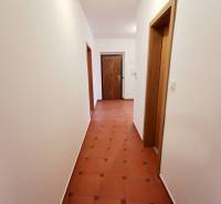 Flur mit hellen Wänden und Fliesen in einer 4-Zimmer-Wohnung.