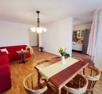 Wohnzimmer einer 4-Zimmer-Wohnung mit roten Sofas und einem Boden in Holzoptik.