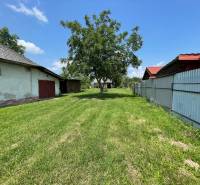 Blick auf ein grünes Grundstück in Zemplínska Široká, ideal zum Wohnen, mit sichtbaren Gebäuden.