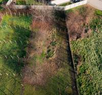 Ein eingezäuntes Grundstück in Vlčkovce mit verstreuten Bäumen, vorgesehen für Wohnzwecke.