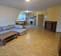 Ein Interieur mit einem Sofa, einer Küche und einem Holzboden in einem Gebäude.