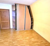 Ein Zimmer mit einem Holzboden, einem Einbauschrank und Holztüren.