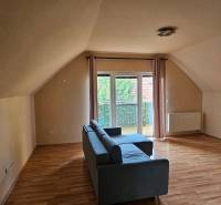 Innenraum eines Gebäudes mit Holzboden, Sofa und Balkon.