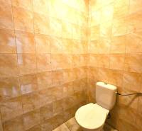 Eine Toilette im Gebäude mit Keramikfliesen und einem Boden mit Marmoroptik.