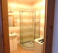 Badezimmer in einem Gebäude mit Fliesen, Duschkabine und Waschmaschine.