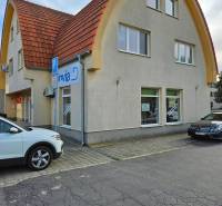 Das Gebäude am Kinderspielplatz in Galanta mit einem gewölbten Dach und Parkplätzen.