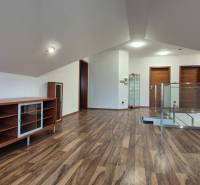 Dachboden in einem Einfamilienhaus mit einem Boden in Holzoptik und eingebauten Schränken.