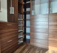 Ein Kleiderschrank im Einfamilienhaus mit Holzdekor und eingebauten Aufbewahrungssystemen.