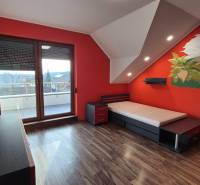 Kinderzimmer mit einer Wand mit Dinosauriermotiven und einem Boden in Holzoptik in einem Einfamilienhaus.