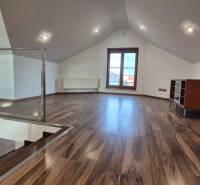 Dachbodenraum mit Holzboden, Treppe und großem Fenster.