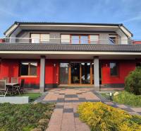 Ein Einfamilienhaus in Krakovany in der Vetrná-Straße, mit roter Fassade und Garten.