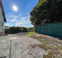 Einfamilienhaus in Podhradí in der Hauptstraße mit Garage, Baum und Betonoberfläche.