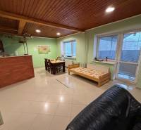 Wohnbereich mit Esstisch, Holzbalkendecke und Bett im Einfamilienhaus.