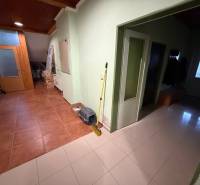 Der Flur eines Einfamilienhauses mit Fliesen, Türen und Kleiderhaken.