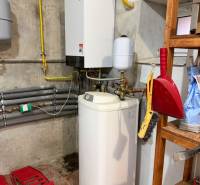 Heizung und Wasserspeicher im Keller eines Einfamilienhauses mit Ausstattung auf dem Regal.