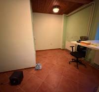 Izba v rodinnom dome s kachličkovou podlahou, stolom, stoličkou a stropným svietidlom.