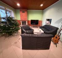 Wohnzimmer in einem Einfamilienhaus mit Weihnachtsbaum, Kamin und Gitarre in der Ecke.